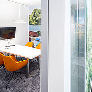Büroraum in der Hannoverschen Volksbank, Schuhmacherstraße 19 mit wandfüllender Fototapete und, Schreibtisch und vier orangenen Stühlen